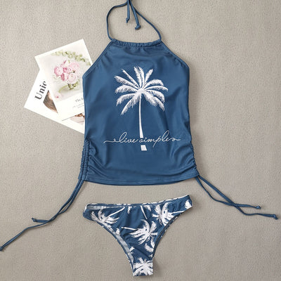 Women's blue halter tankini top with white palm tree graphic and "live simple" text, paired with matching high-waist bikini bottoms with palm print and side tie - Image 12