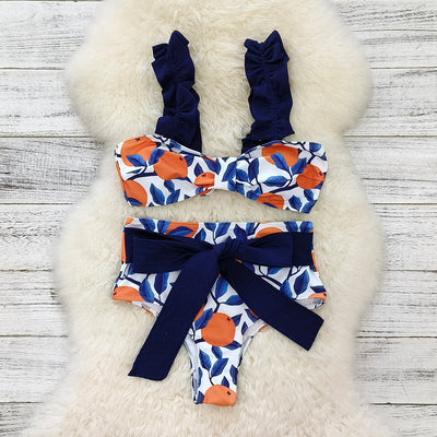Women's high-waisted bikini swimsuit with orange and blue leaf print, ruffled navy blue straps, and a tie-front belt. - Image 4