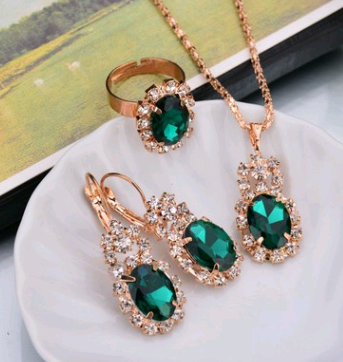 Rose gold-toned necklace, earrings, and ring set with large oval clear gemstones surrounded by smaller stones. - Image 6