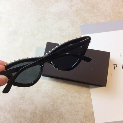 Two pairs of cat-eye sunglasses, one black with clear rhinestones and one pink with pink rhinestones, on a light surface. - Image 4
