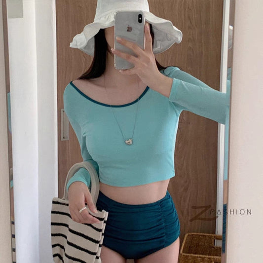 Woman in a pink long-sleeved crop top and black high-waisted ruched swim bottoms, posing in a mirror. - Image 2