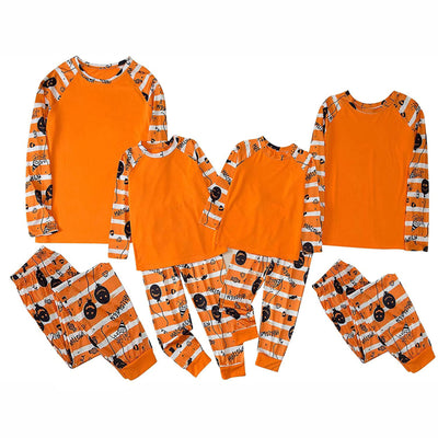 Family of four wearing matching orange and white striped Halloween pajamas with pumpkin and bat prints. - Image 2