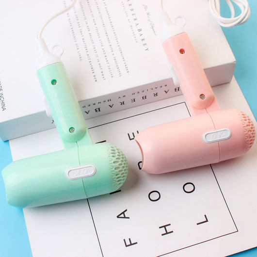 Light blue foldable hair dryer with a cartoon pig design, white power switch, and hanging loop. - Image 4