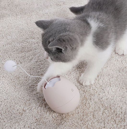White egg-shaped automatic cat toy with a yellow interior and a flexible wire holding a yellow fuzzy ball. - Image 3