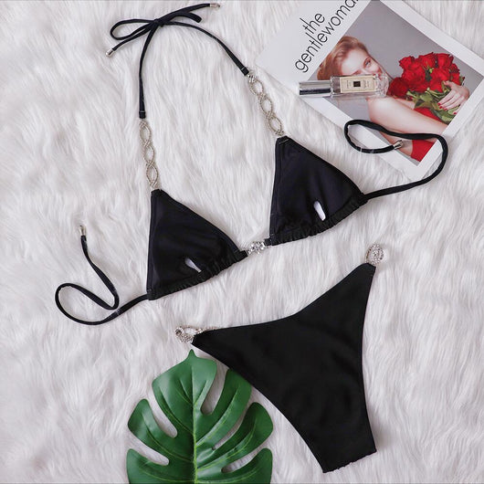 Black two-piece bikini with rhinestone chain halter straps and connectors, laid flat on white faux fur. - Image 8