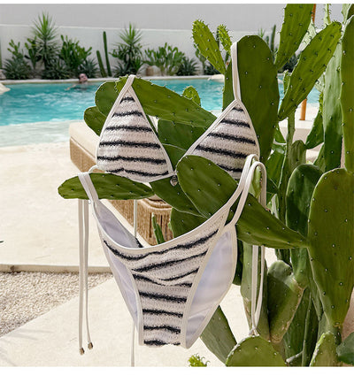 White and black striped bikini with triangle-cut top and tie-side bottom, modeled outdoors. - Image 20