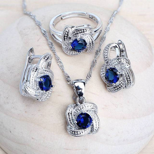 Blue zirconia jewelry set with silver-toned necklace, bracelet, ring, and earrings, featuring swirling designs. - Image 11