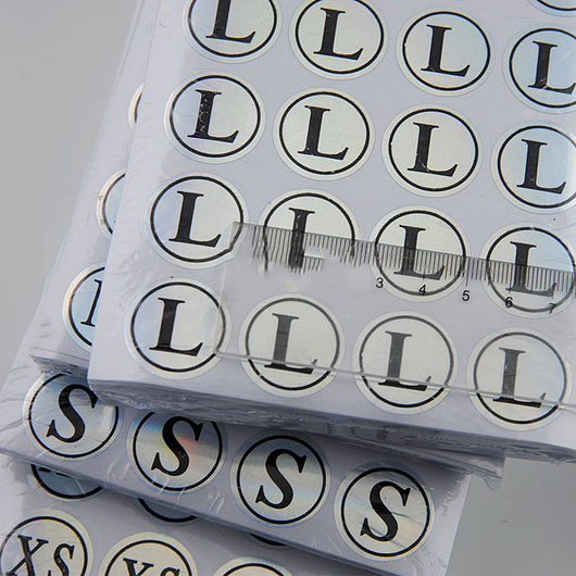 Stack of round clothing size stickers with laser color-changing background and black text, from XS to 4XL. - Image 4