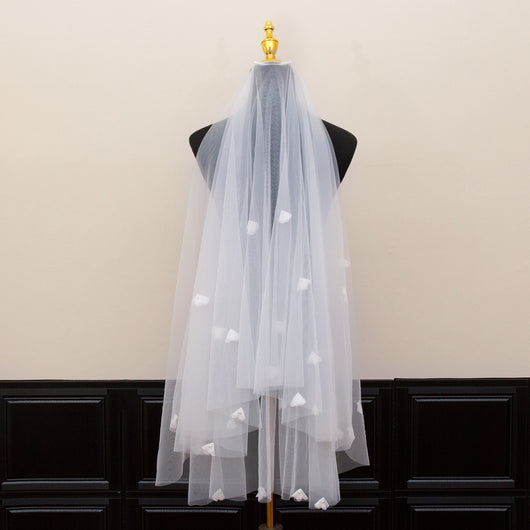 White and ivory sheer fabric swatches for a wedding veil displayed on green grass. - Image 3