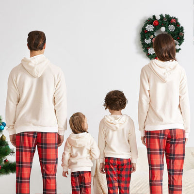 Family of four wearing matching cream fleece reindeer pajamas with red plaid pants, posing for a Christmas photo. - Image 24