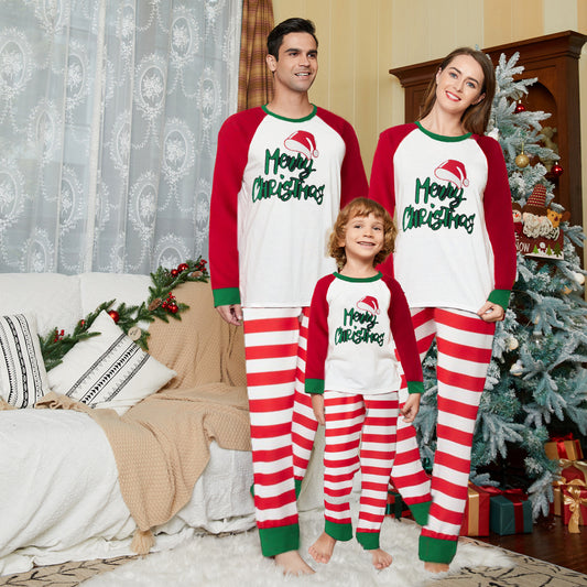 Matching family Christmas pajamas with red and white stripes, green trim, and "Merry Christmas" text with a Santa hat.