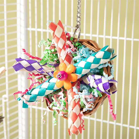 Colorful parrot bird toy with a woven basket base, braided chew sticks, crinkled paper, and a metal hanging chain. - Image 6