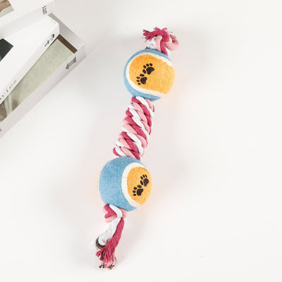 Red, pink, and white braided cotton rope dog toy with a green and red tennis ball featuring black paw prints. - Image 6