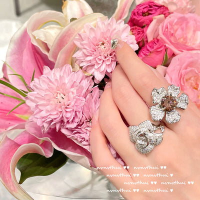 Pair of sparkling rose-shaped stud earrings, encrusted with clear gemstones, displayed in a brown jewelry box. - Image 10