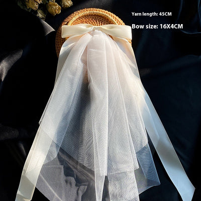 White birdcage veil with a cream satin bow and faux pearls, attached to a woven straw base, 80cm yarn length. - Image 13