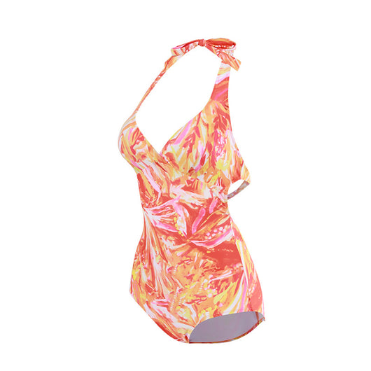 Woman in an orange and pink patterned halter neck backless cover-up dress with a straw hat on a sandy beach. - Image 8