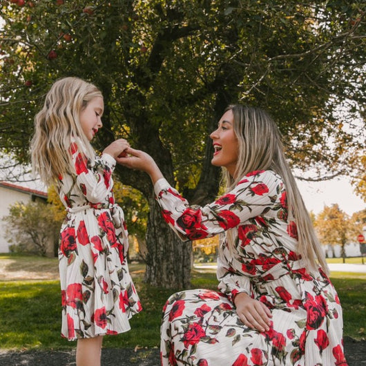 Mother and daughter in matching white dresses with red floral print, V-neck, long sleeves, and tie-waist. - Image 5