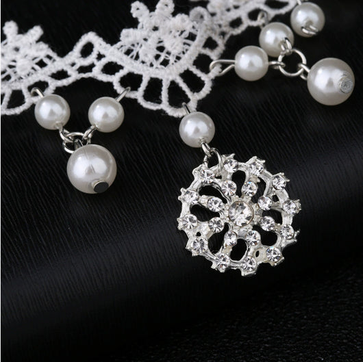 White lace choker necklace with dangling faux pearls and a central rhinestone pendant on a black jewelry bust. - Image 8