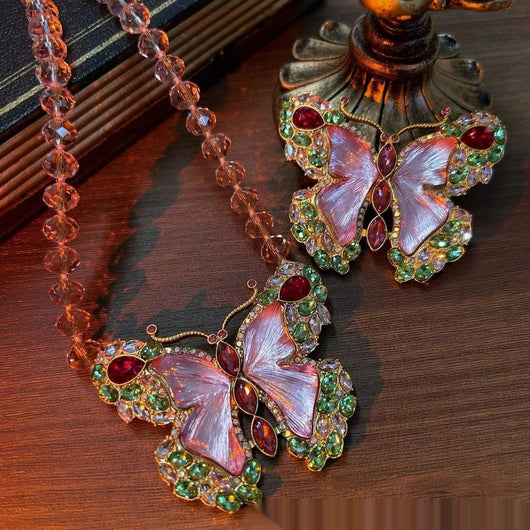 Pink enamel butterfly brooch with green, red, and clear rhinestones set in gold-toned metal. - Image 14
