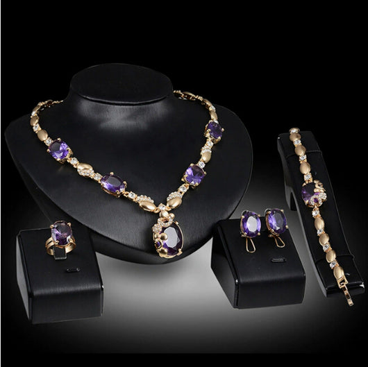 Four-piece gold-toned jewelry set with oval purple gemstones: necklace, ring, earrings, and bracelet. - Image 5