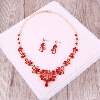 Red rhinestone bridal jewelry set featuring a floral necklace and matching dangle earrings on a model. - Image 14