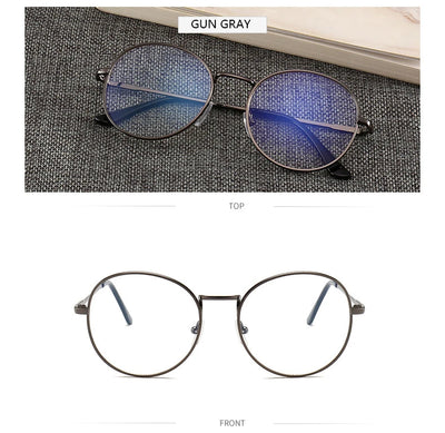 Black round anti-blue light glasses with clear lenses showing a blue reflection, resting on a gray textured surface. - Image 8