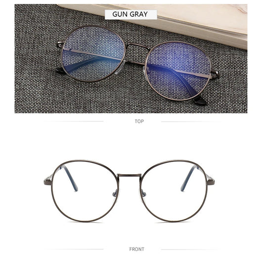 Black round anti-blue light glasses with clear lenses showing a blue reflection, resting on a gray textured surface. - Image 8