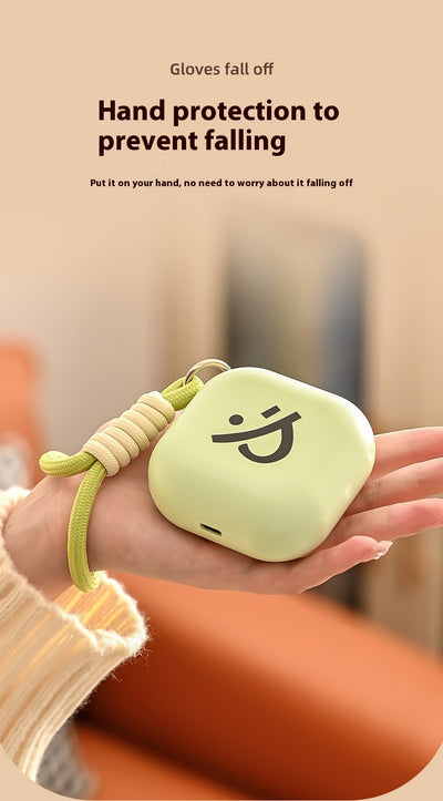 Light green square hand warmer with rounded corners and a black smiley face, hanging from a two-tone lanyard. - Image 9