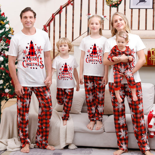 Family of five wearing matching Christmas pajamas with white 'Cousin Crew' tops and red plaid snowflake pants.