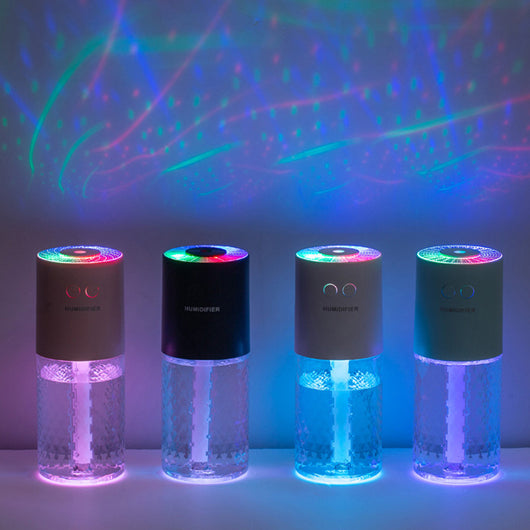 Dark blue and clear portable humidifier with a textured water tank on a white desk next to a laptop. - Image 4