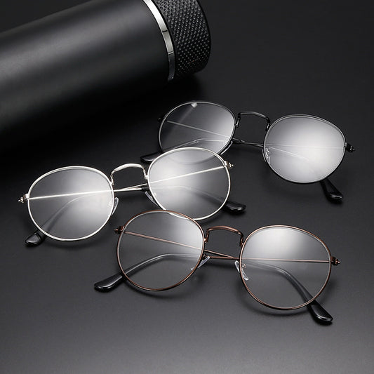 Retro oval anti-blue light glasses with a dark metal frame and clear lenses on a white background.