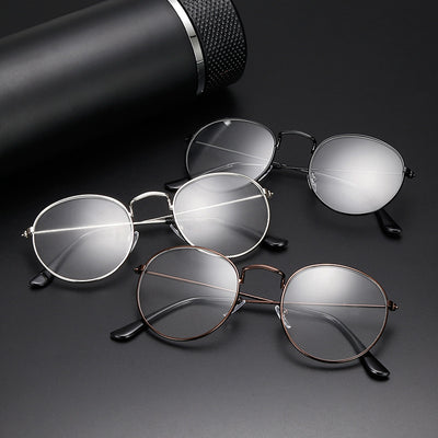 Retro oval anti-blue light glasses with a dark metal frame and clear lenses on a white background.