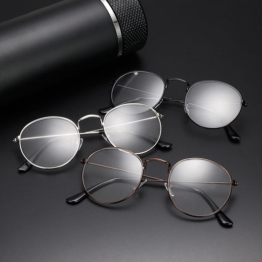 Retro oval anti-blue light glasses with a dark metal frame and clear lenses on a white background.