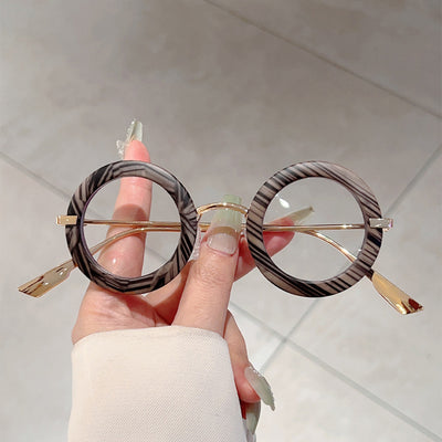 Small frame oval fashion sunglasses with black frames and vibrant orange lenses, held by a hand. - Image 13