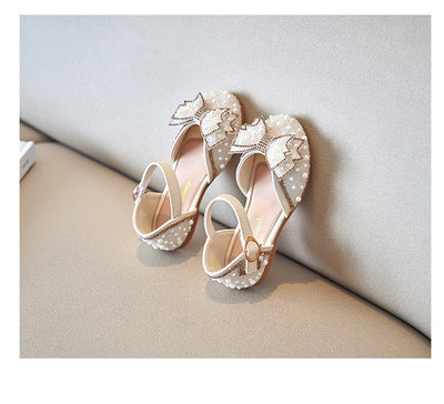 Beige girls' shallow mouth pumps with a large pink pearl bow, glitter, and an ankle strap with a gold buckle. - Image 11