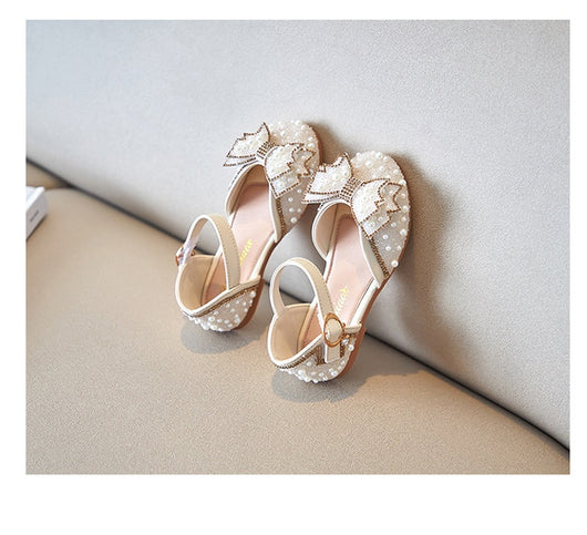 Beige girls' shallow mouth pumps with a large pink pearl bow, glitter, and an ankle strap with a gold buckle. - Image 11