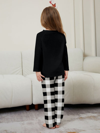 Family of four wearing matching black long-sleeve pajamas with "WE ARE FAMILY" text and black and white plaid bottoms. - Image 18