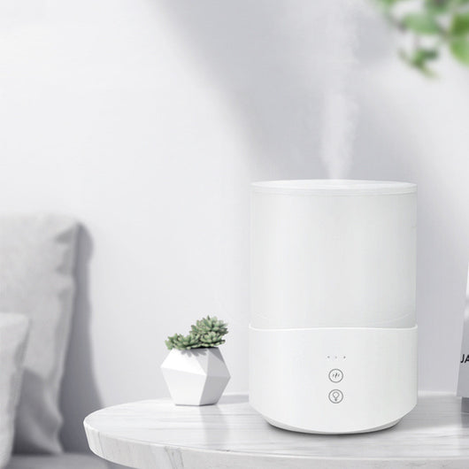 White cylindrical household humidifier with a translucent top section glowing blue, featuring two control buttons. - Image 5