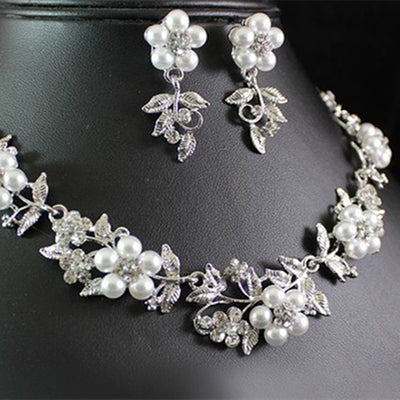 Silver-tone bridal necklace and earring set with white pearls and clear rhinestones in a floral leaf design.