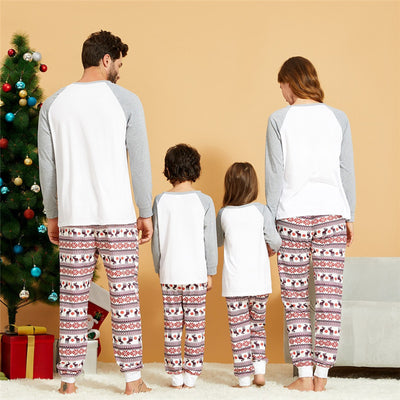 Young boy wearing a Christmas pajama set with a white and grey raglan top featuring a reindeer and fair isle print pants. - Image 4