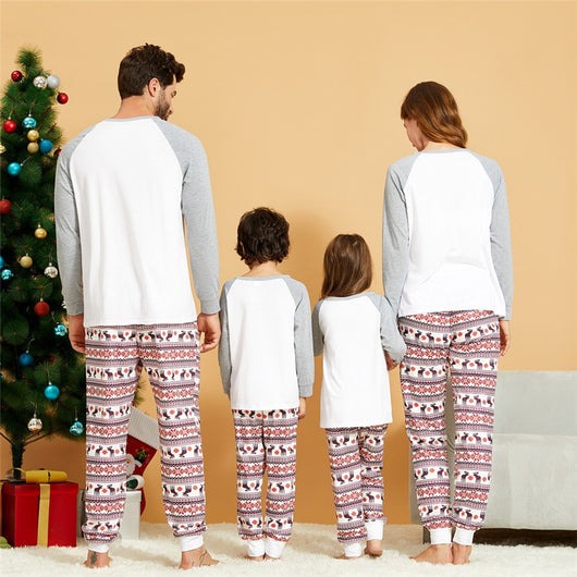 Young boy wearing a Christmas pajama set with a white and grey raglan top featuring a reindeer and fair isle print pants. - Image 4