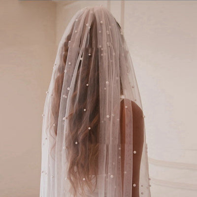 Mid-length white bridal veil with scattered pearl embellishments, flowing elegantly on a mannequin. - Image 8