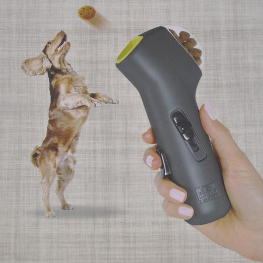 Dog Treat Launcher in retail packaging, a gray handheld device for dispensing snacks during training or playtime.