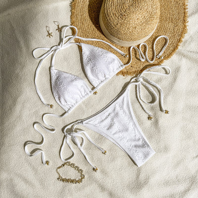 White halter lace-up bikini with a textured pattern, styled with a straw hat and gold jewelry on a sandy background. - Image 5