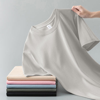 Light gray short-sleeve t-shirt with a round neck, held up to show its smooth fabric. A stack of folded t-shirts in various colors is visible in the background. - Image 10