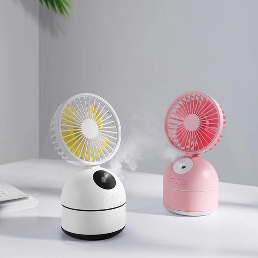 Dark grey fan humidifier with a round fan head and spherical base, emitting mist, on a white desk. - Image 4