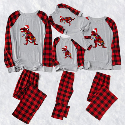Family of four and golden retriever in matching red and black plaid deer Christmas pajamas, by a decorated tree. - Image 3