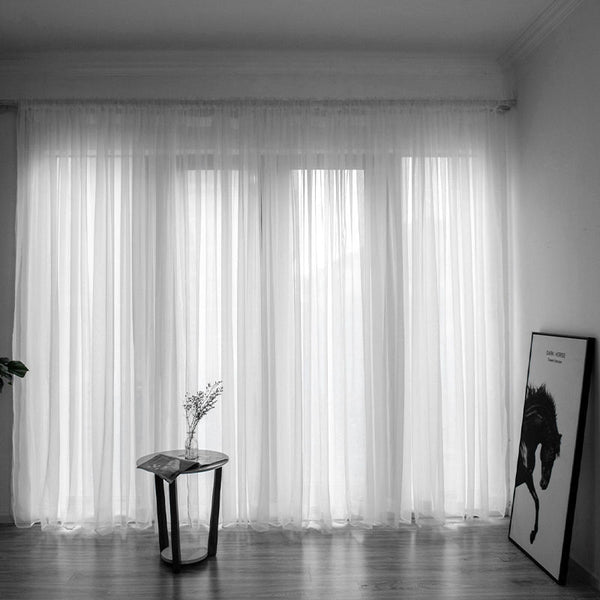 Simple and modern black sheer gauze curtain hanging on a rod in front of a window, filtering light. - Image 16