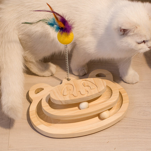 White cat playing with a wooden multi-level track toy featuring a spring-mounted yellow feather ball and a green catnip ball. - Image 9