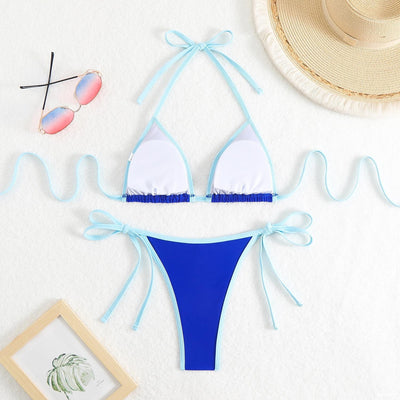 Royal blue two-piece bikini with light blue trim and tie straps, laid flat on a white textured surface. - Image 17